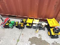 Group shot of all eight toy vehicles lined in a row outdoors