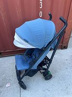 Left front view showing blue canopy, seat, black frame