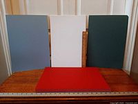 Front view showing blue, white, green upright boards and red stack with rulers for scale
