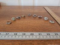 All nine rings lined up beside ruler for scale