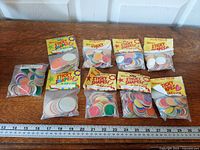 All nine sealed sticker packs arranged with ruler for scale