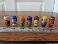 All seven Mighty Beanz lined up with ruler for scale