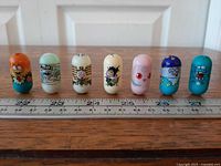 All seven Mighty Beanz aligned beside ruler