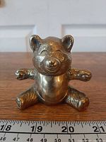 Front view of brass bear with ruler for scale