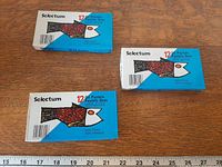 Three unopened Selectum 12-count oil pastel boxes on table with ruler for scale