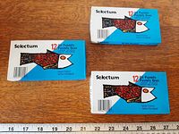 Three sealed Selectum 12 oil pastels boxes on table with ruler for scale