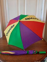 Open umbrella showing multicolor canopy and closed umbrella beside