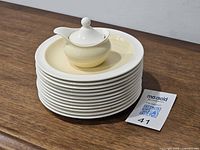 Stack of 12 plates with covered vessel on top