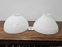 Both milk glass shades side by side showing patterns and fitter openings