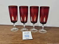 Front view of four red Luminarc champagne flutes