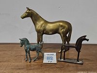 Group view of three metal horse figures