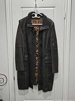 Front view of Danier leather coat hanging on door