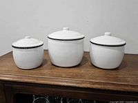 Front view of all three enamel canisters with lids on