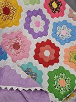 Close view of multicolored hexagon flower blocks showing hand stitching