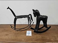 Both rocking horse figurines side by side on table