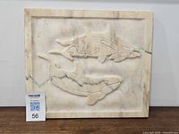 Front view of marble plaque showing whale relief carving