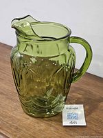 Front angled view of green glass pitcher