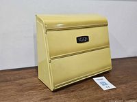 Front view of yellow metal foil dispenser showing nameplate