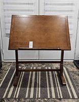Front view of wood drafting table with tilting top