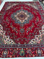 Full view of red handmade Tabriz rug showing overall design and borders