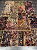 Full view of the patchwork Persian rug on dark wood floor