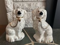 Front view of both spaniel figurines showing gilded collars and chains