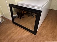 Front view of mirror showing black frame and glass