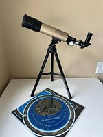 Telescope on tripod beside planisphere