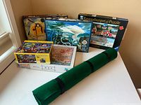 Group shot showing all five puzzle boxes and rolled puzzle mat
