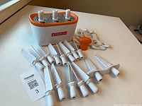 Zoku 3-pop maker base with three sticks inserted, extractor tool and additional sticks displayed
