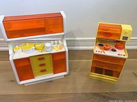 Both Barbie kitchen furniture units with accessories displayed