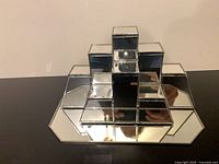 Front view of stacked cube mirrored glass stand on hexagonal mirrored base