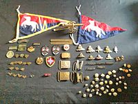 Overview of pennants, miniature cannon, insignia, buckles, buttons, patches