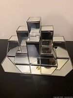 Frontal view showing stacked cube mirrored stand on mirrored base