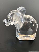 Left-side view of faceted crystal elephant showing metal tail and raised trunk