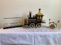 Lot overview showing locomotive set, shot glass rack and swizzle stick cart