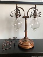 Full view of lamp showing dual arms, shades, wooden base and cord