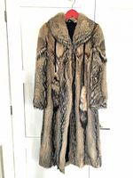 Front view of full-length brown/black fur coat on hanger
