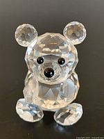 Front view of clear faceted crystal bear showing eyes, nose, seated body