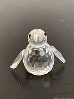 Front view of clear faceted crystal penguin with wings spread
