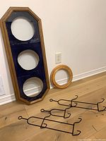 Group view of elongated octagonal frame, round frame, three metal racks