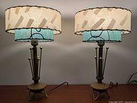Both lamps lit showing full design, shades, rods, base