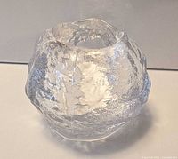 Front angled view of the Kosta Boda clear glass snowball votive showing overall shape and texture