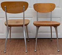 Front view of both chairs showing aluminium frames and wood seats/backs