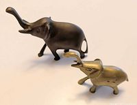 Both brass elephant figurines side view showing size difference and finishes