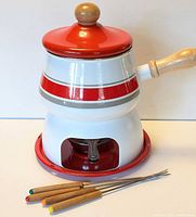 Complete fondue set assembled showing pot, stand, tray and forks