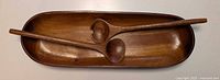 Top view showing oval wooden bowl with spoon and fork inside