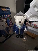 Front view of polar bear figure next to box and lantern parts