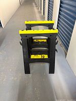 Front view of two black plastic Stanely folding sawhorses stacked