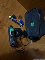 Overview of both razors, charging base, power cord and Axe toiletry bag